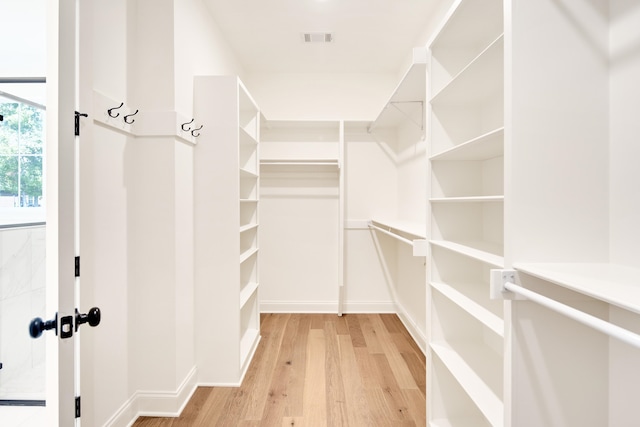 walk in closet featuring light wood-type flooring and visible vents