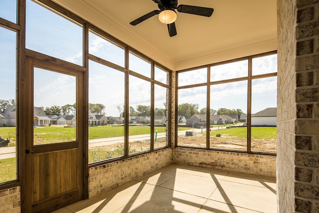 unfurnished sunroom with ceiling fan