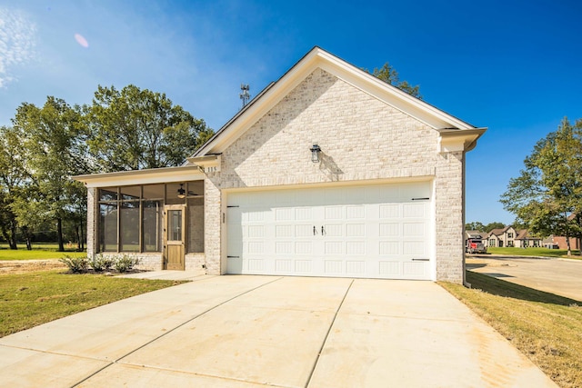 view of front facade featuring brick siding, concrete driveway, an attached garage, a front yard, and a sunroom