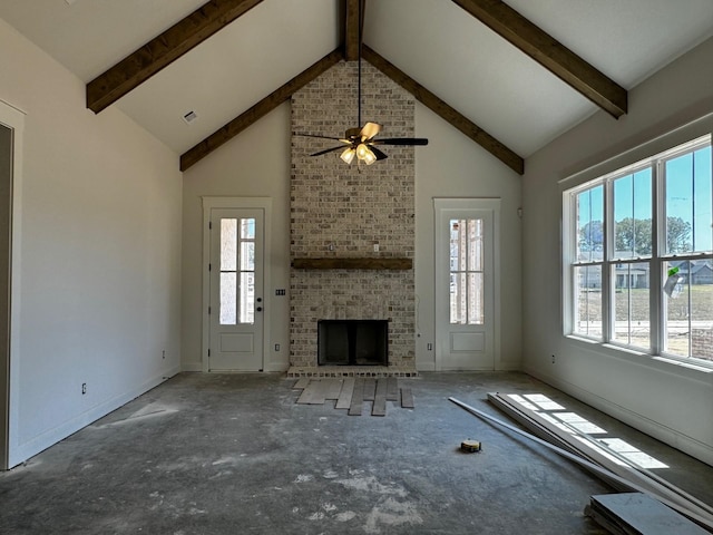 unfurnished living room with ceiling fan, beam ceiling, high vaulted ceiling, and a brick fireplace