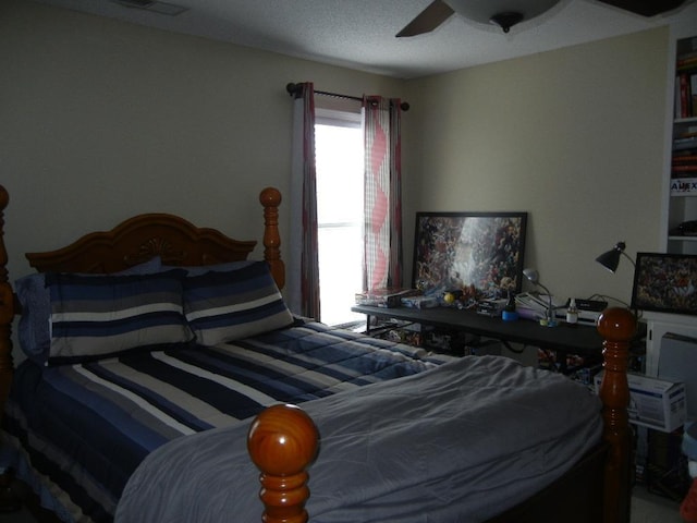 bedroom with ceiling fan and a textured ceiling