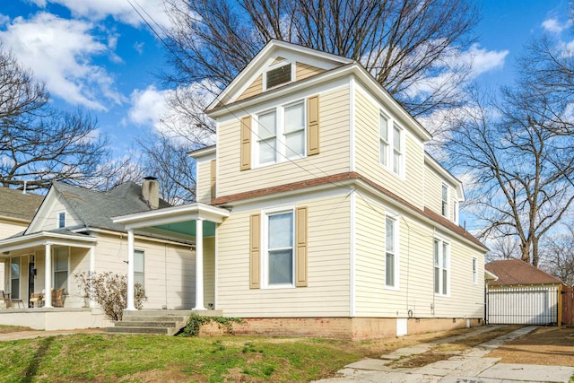 view of front of house featuring a porch, a garage, and an outdoor structure