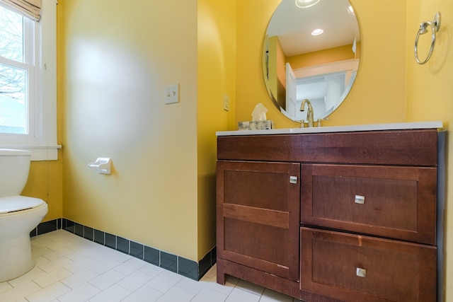 bathroom with tile patterned flooring, vanity, toilet, and a wealth of natural light