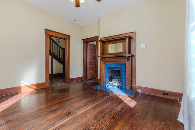 unfurnished living room featuring dark hardwood / wood-style flooring and ceiling fan