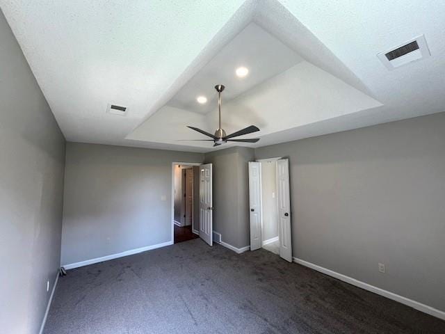 unfurnished bedroom with ceiling fan and dark carpet