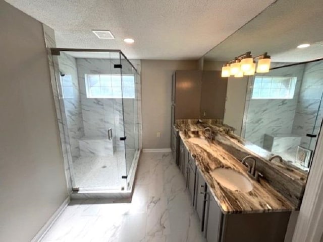 bathroom with vanity, a shower with door, a textured ceiling, and a wealth of natural light