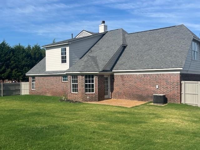 rear view of property with a yard, a patio, and cooling unit