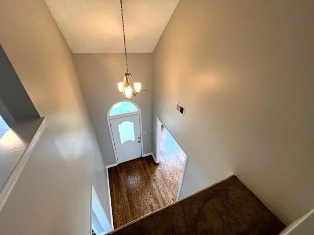 entryway featuring a towering ceiling and an inviting chandelier