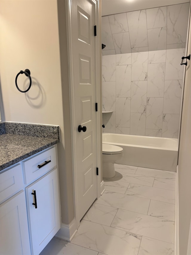 full bathroom featuring vanity, tiled shower / bath combo, and toilet