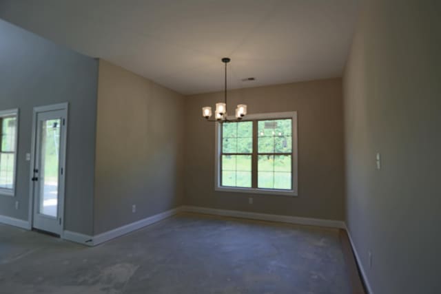 spare room featuring an inviting chandelier