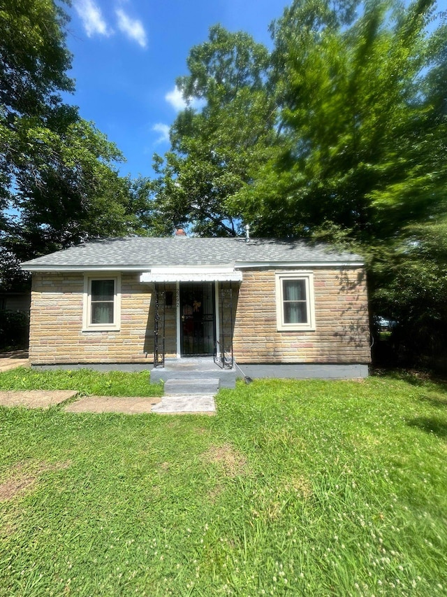 back of property featuring a yard