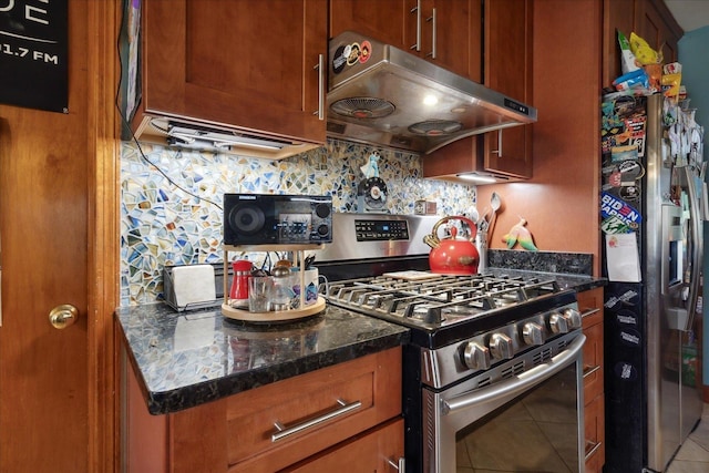 kitchen featuring tile patterned floors, dark stone countertops, tasteful backsplash, and appliances with stainless steel finishes