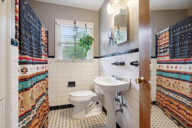 bathroom featuring walk in shower, tile patterned floors, toilet, and tile walls