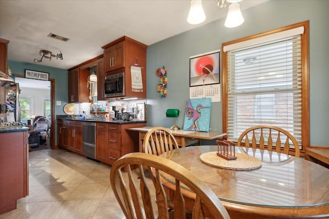 tiled dining room featuring a wealth of natural light and sink