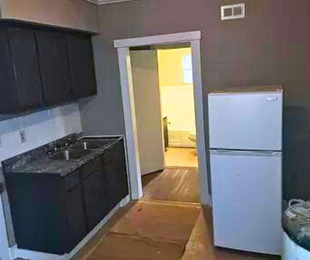 kitchen featuring white refrigerator and sink