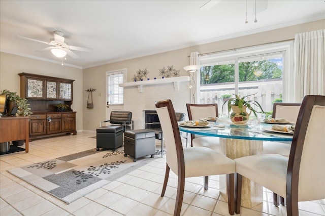 dining space featuring ceiling fan, a healthy amount of sunlight, light tile patterned floors, and ornamental molding