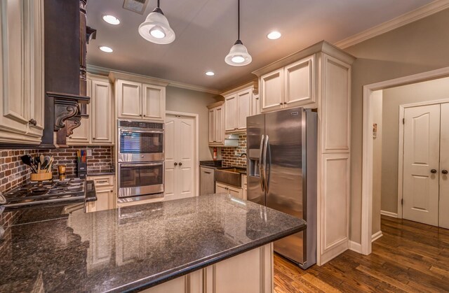 kitchen featuring visible vents, hanging light fixtures, appliances with stainless steel finishes, dark wood-style floors, and crown molding