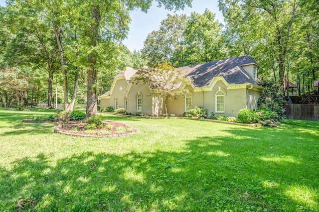 view of front of home with a front yard, brick siding, and fence