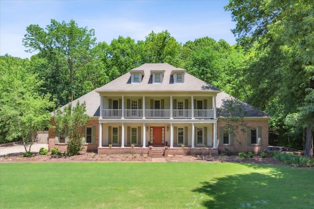 view of front of home featuring a balcony, a front lawn, and a porch