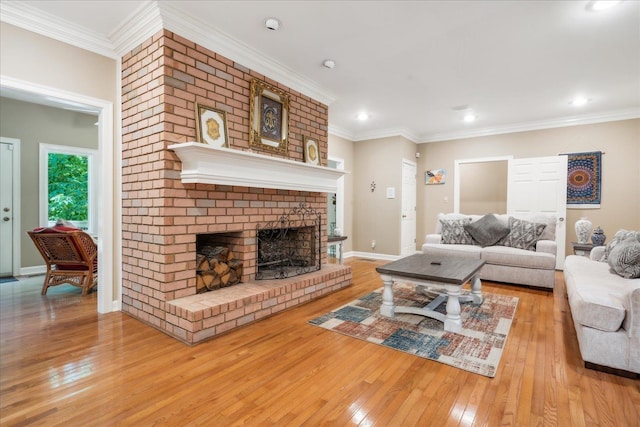 living room with light hardwood / wood-style flooring, a brick fireplace, and crown molding