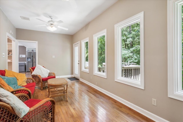 living area with ceiling fan and light hardwood / wood-style floors