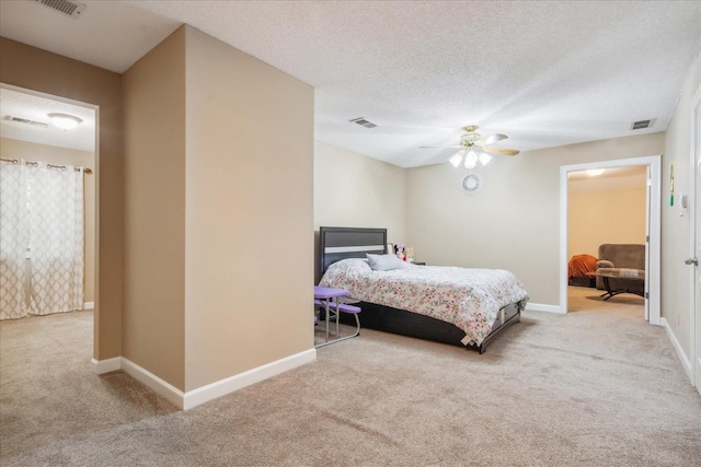 carpeted bedroom with ceiling fan and a textured ceiling