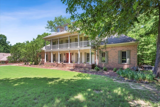 view of front of property featuring covered porch, a balcony, and a front lawn