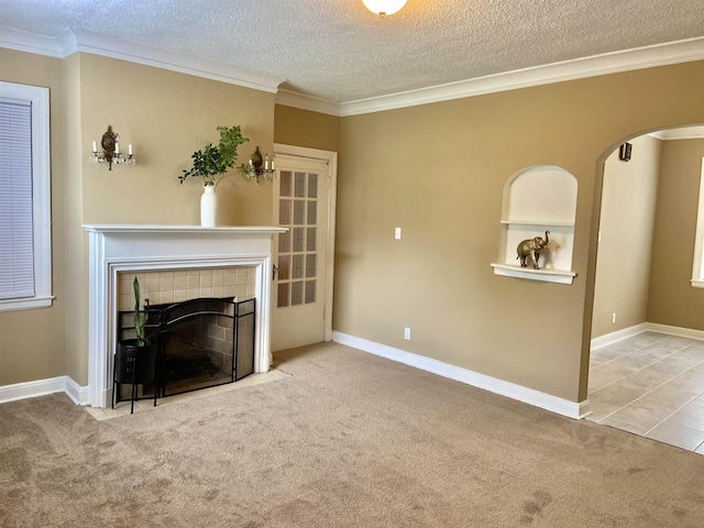 unfurnished living room featuring carpet, a textured ceiling, and a tiled fireplace