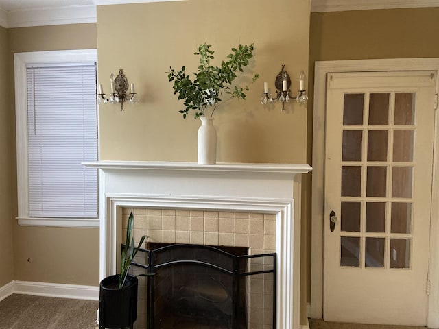 room details featuring carpet flooring, crown molding, and a fireplace