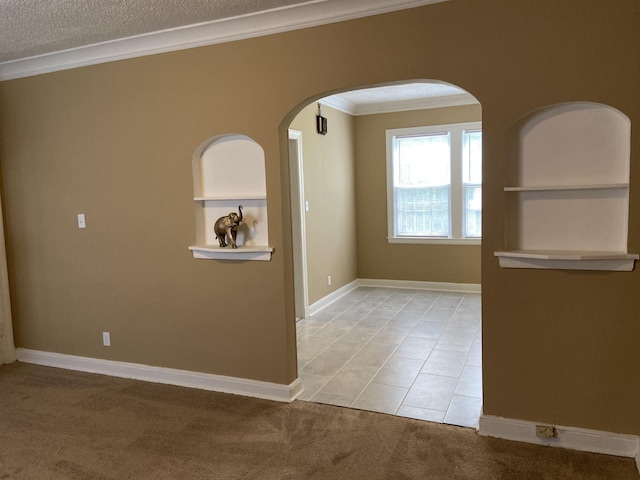 carpeted spare room with crown molding and a textured ceiling