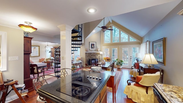 kitchen featuring french doors, ceiling fan, light stone counters, a fireplace, and dark hardwood / wood-style flooring