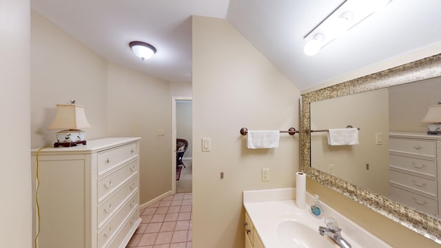 bathroom with tile patterned flooring, vanity, and vaulted ceiling