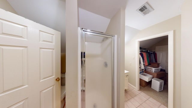 bathroom featuring walk in shower and vaulted ceiling