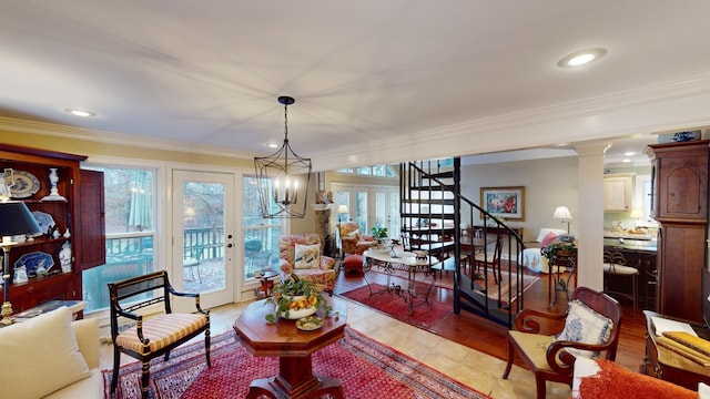 living room with french doors, light hardwood / wood-style flooring, an inviting chandelier, and ornamental molding