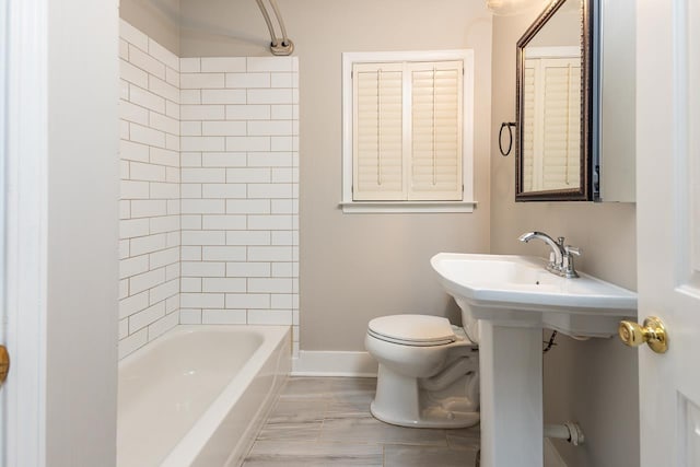 bathroom featuring toilet and tiled shower / bath combo