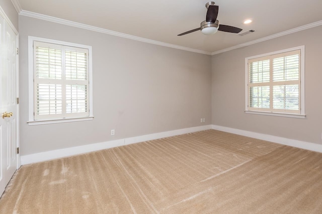 carpeted spare room featuring crown molding, ceiling fan, and plenty of natural light