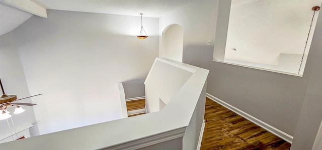 staircase with wood-type flooring, lofted ceiling with beams, and ceiling fan