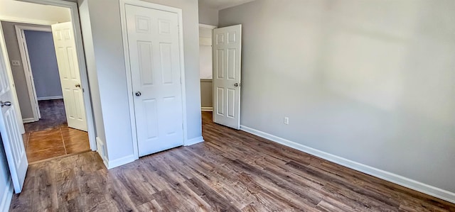 unfurnished bedroom featuring wood-type flooring and a closet