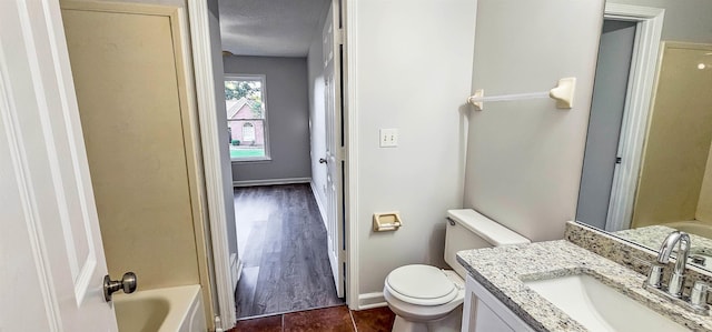 bathroom featuring vanity, toilet, and a textured ceiling