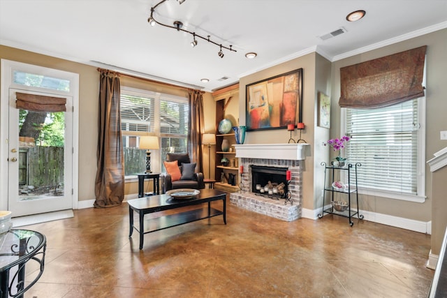 living room featuring rail lighting, ornamental molding, and a fireplace