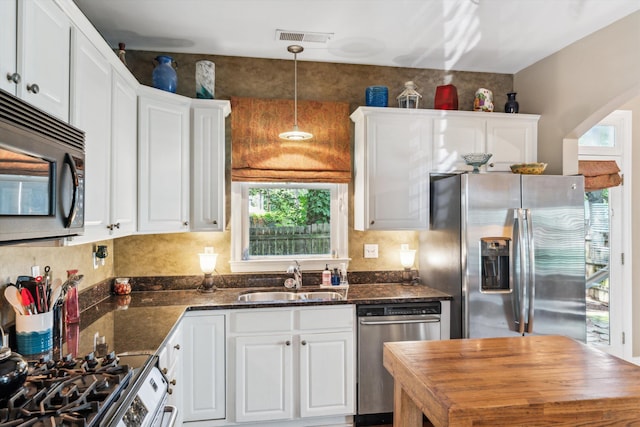 kitchen with pendant lighting, sink, white cabinets, and stainless steel appliances