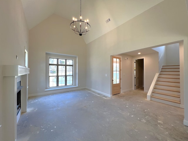 unfurnished living room featuring high vaulted ceiling, concrete flooring, and a notable chandelier