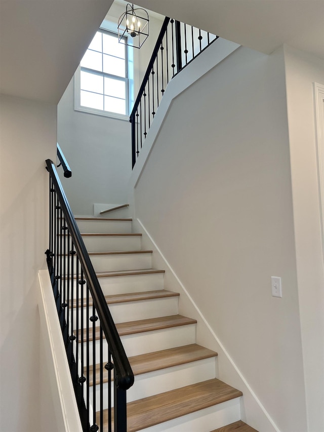 stairs with a notable chandelier