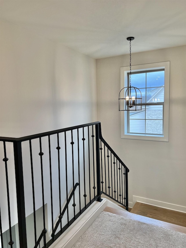 stairs featuring a chandelier