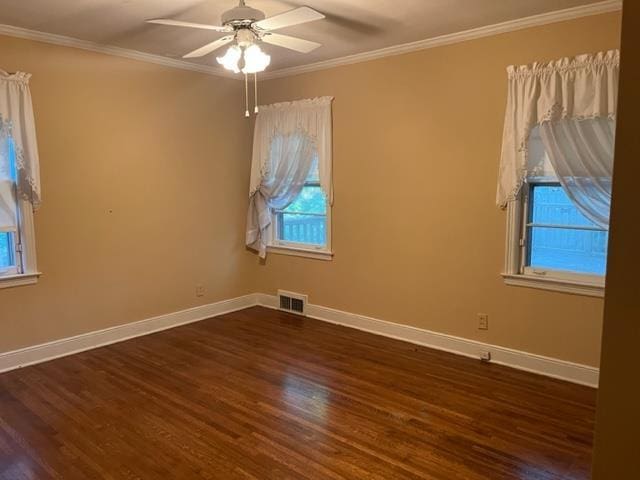 spare room featuring dark wood-type flooring, ceiling fan, and crown molding