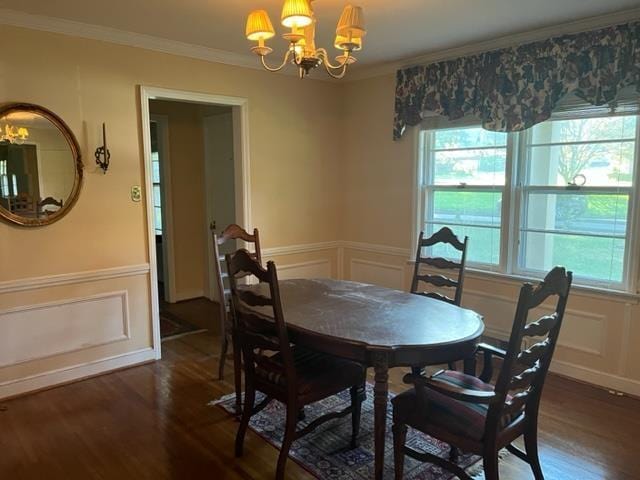 dining space featuring dark hardwood / wood-style flooring, an inviting chandelier, and crown molding