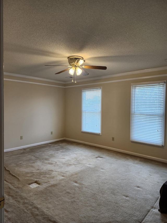 carpeted spare room featuring plenty of natural light, crown molding, and ceiling fan