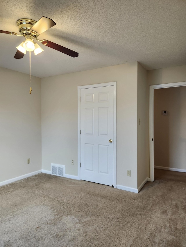 spare room featuring carpet, a textured ceiling, and ceiling fan