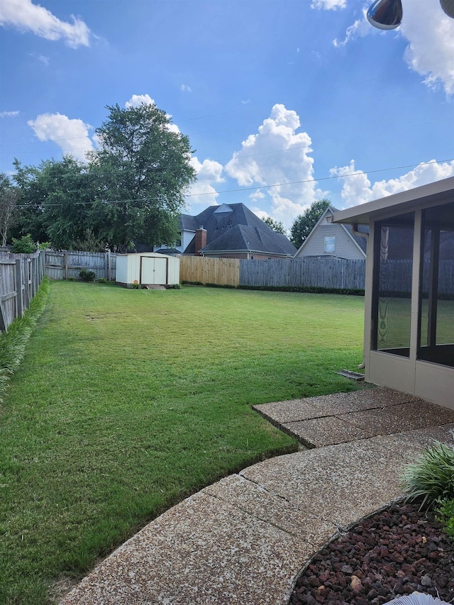 view of yard featuring a sunroom and a storage unit