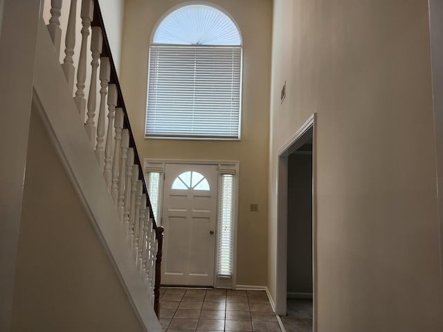 foyer featuring tile patterned floors and a high ceiling